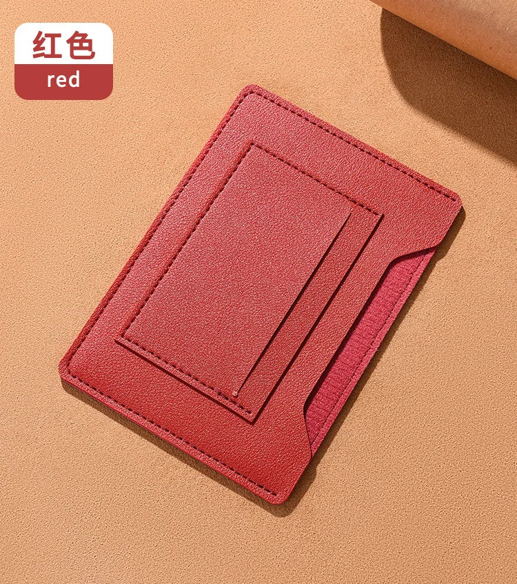 Portefeuille de voyage fin rouge pour passeport et documents sur fond beige.