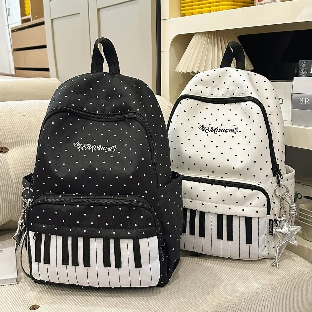 Sac à dos noir et blanc à pois avec un clavier de piano, présenté sur une surface claire.