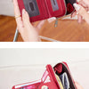 A close-up of a red leather wallet being held by a hand, showing the interior and exterior details.