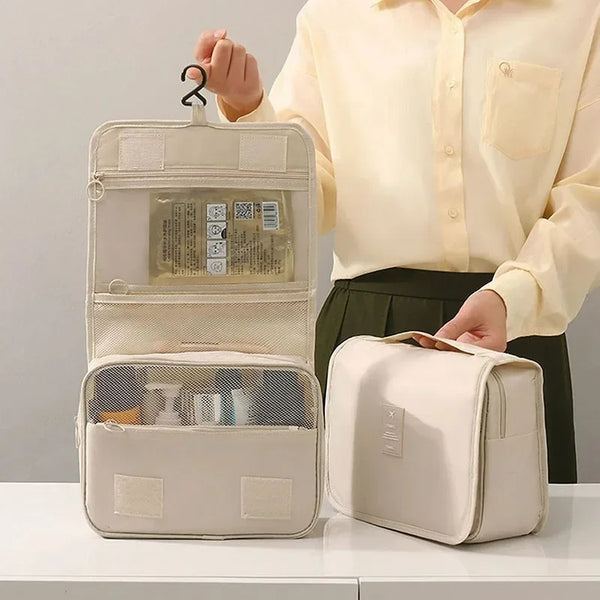 Una persona sostiene un organizador y bolsa de viaje para maquillaje impermeable color beige con forro de malla.