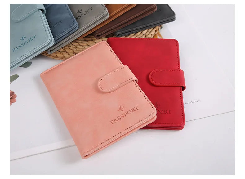 Un porte-passeport en cuir rose et un portefeuille en cuir rouge sont exposés sur un fond blanc.