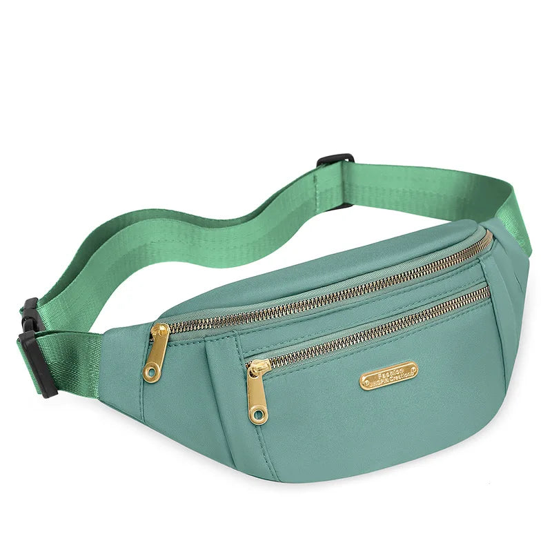Petit sac banane imperméable vert menthe à bandoulière avec fermeture éclair et quincaillerie dorée.