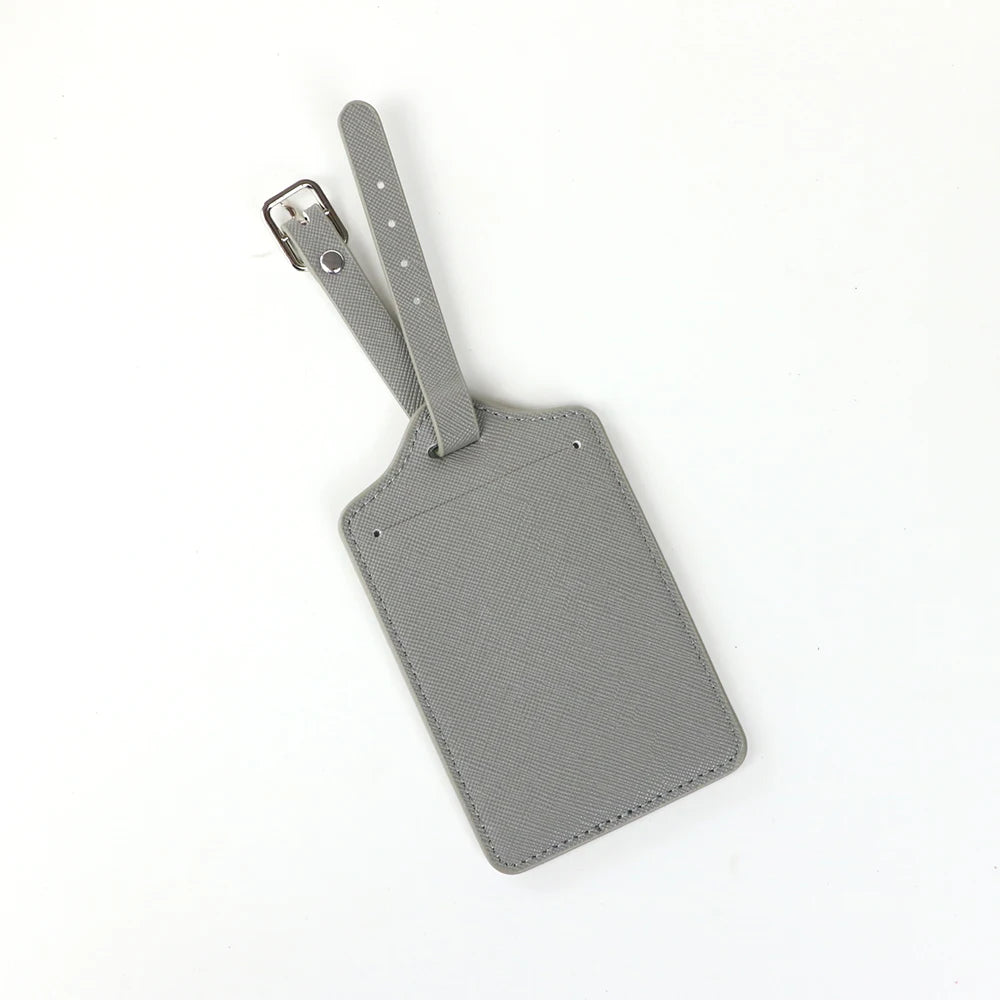 A set of two gray PU leather luggage tags with a cross-pattern detail and attached leather straps.
