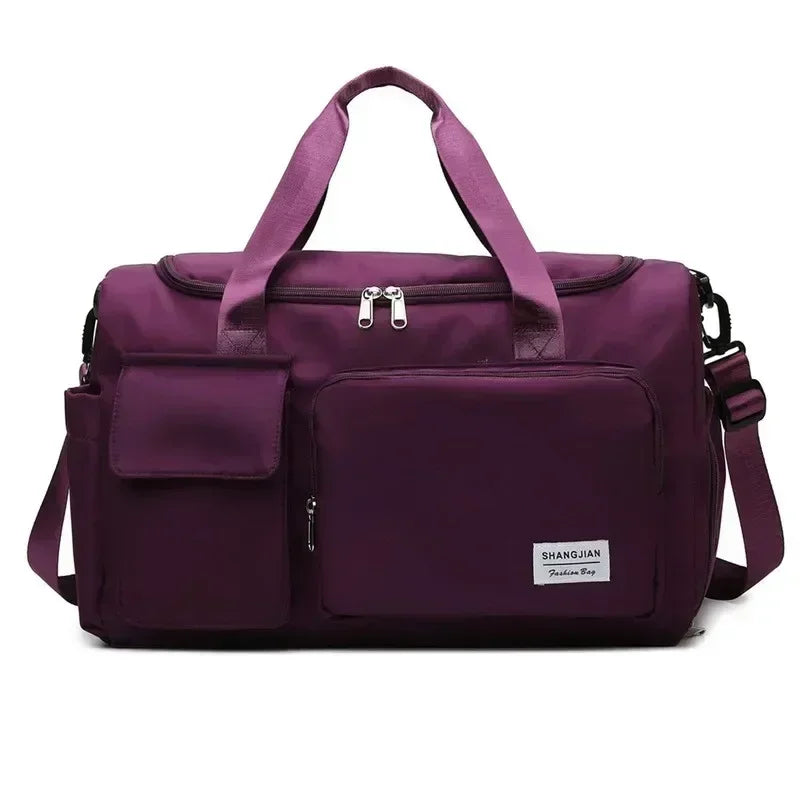 A purple large capacity travel duffle bag with shoulder straps and a zippered compartment.