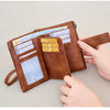 A brown leather multi-slot wallet with RFID blocking features is shown open, displaying various cards and cash.