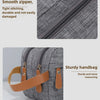 A gray portable travel storage pouch with a smooth zipper and tan leather strap.