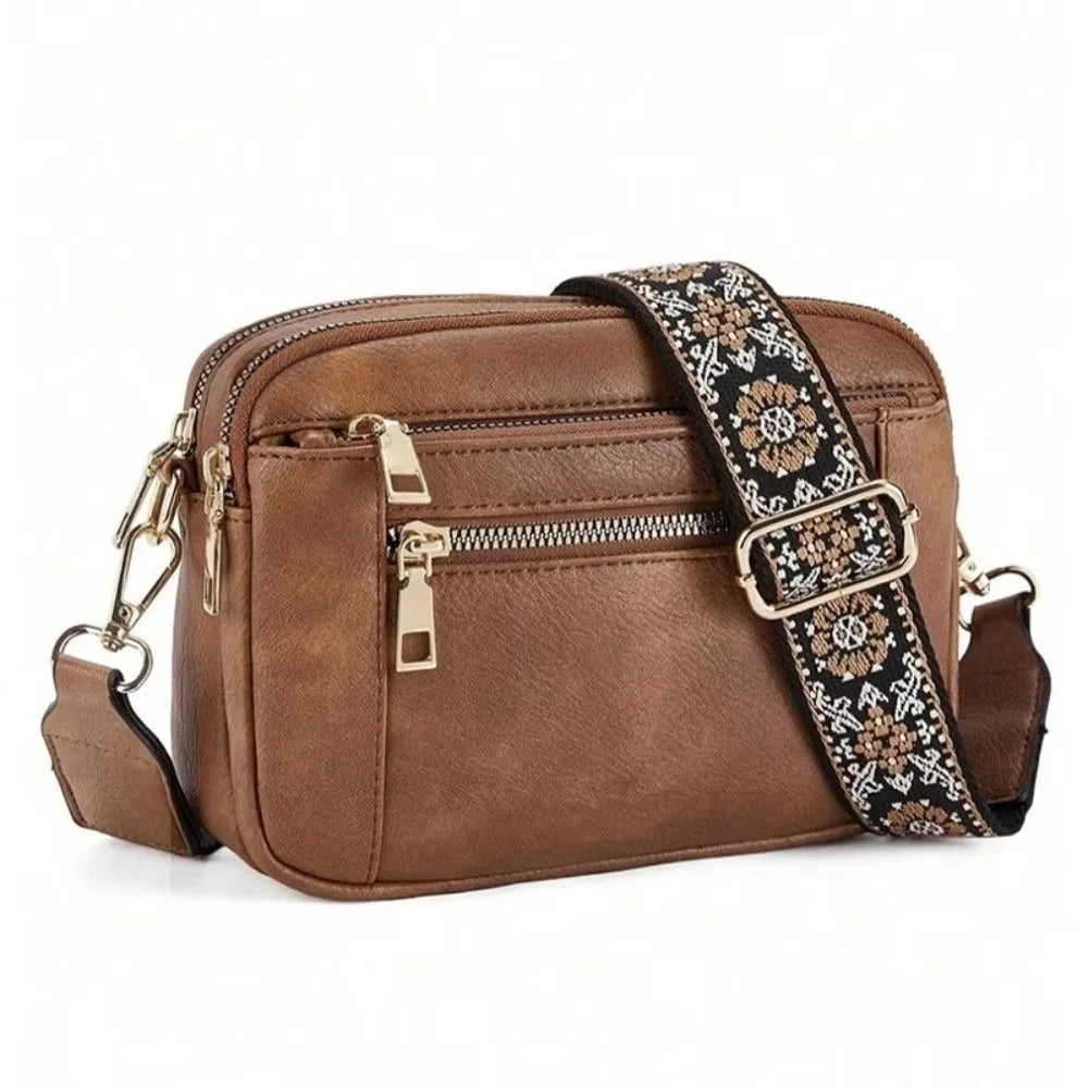 A brown leather retro square crossbody bag with a patterned strap and gold hardware.