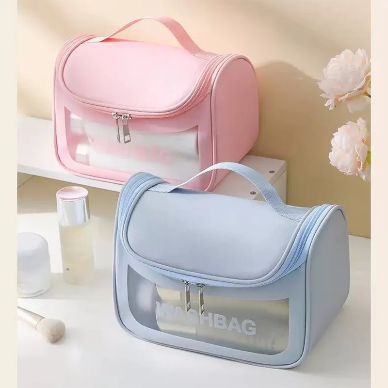 Une trousse de toilette transparente bleu clair et imperméable suspendue à côté d'une rose sur une surface blanche.