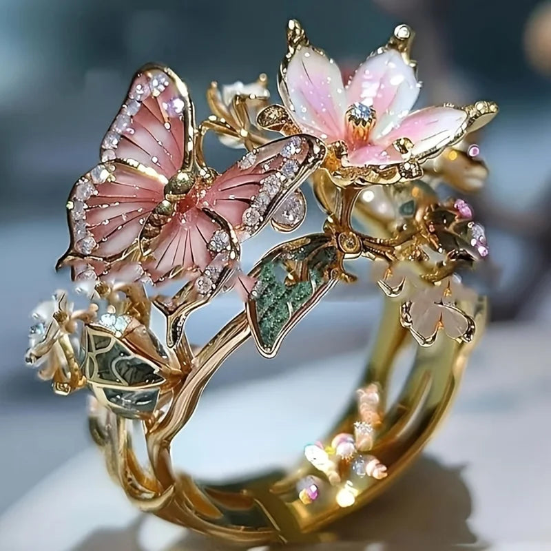 Gold rings featuring delicate pink and white flower and butterfly designs