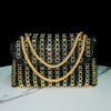 A black leather evening clutch bag adorned with gold-toned rhinestone detailing and gold chain straps.