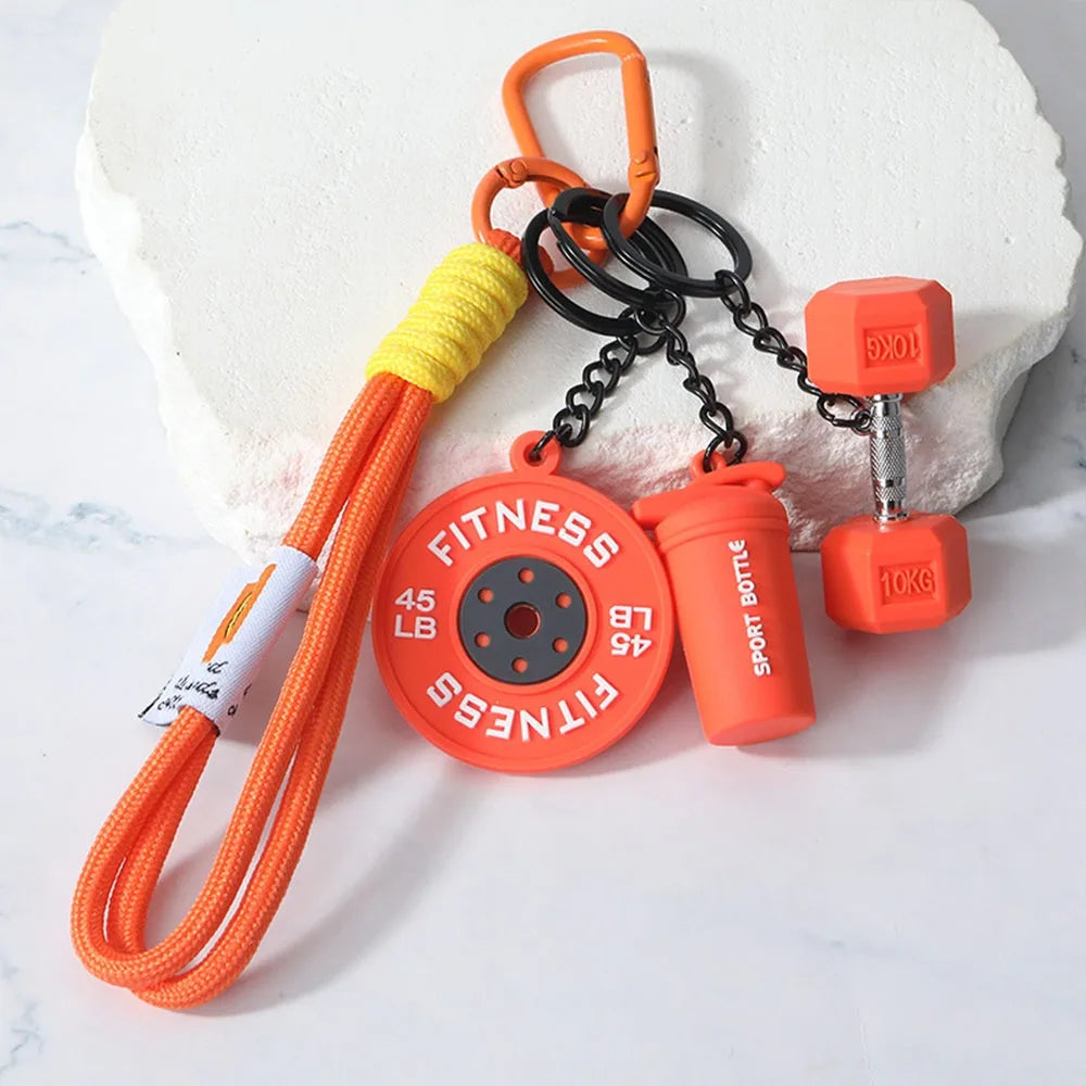 Orange fitness dumbbell keychain charm with a yellow cord and a red weight plate