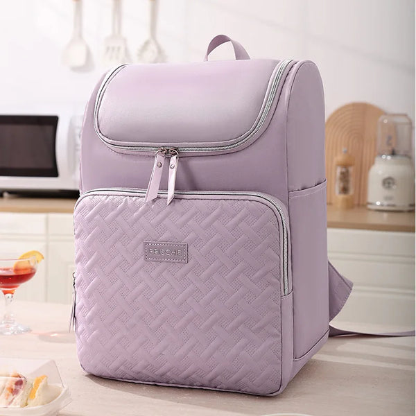 Una mochila isotérmica para picnic de color lila claro, apoyada sobre una mesa.