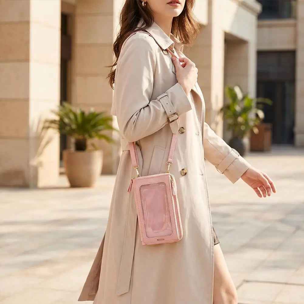 Eine Frau trägt einen beige Trenchcoat und hält eine rosa Touchscreen-Crossbody-Handtasche.