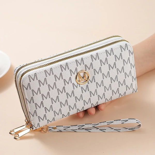 A light beige patterned double zipper wallet with a gold accent is shown being held by a hand.
