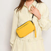A woman wearing a cream shirt holds a bright yellow multi-functional passport and document organizer.