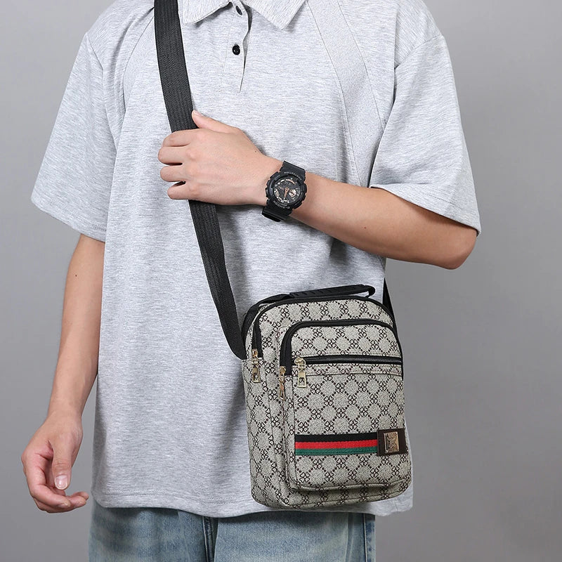 A man wearing a gray shirt and jeans is holding a black strap for a versatile men's crossbody sling bag.