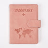 A pink leather passport wallet cover featuring the word PASSPORT and a world map silhouette.