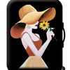 A woman wearing a wide-brimmed hat holds a sunflower against a black suitcase.