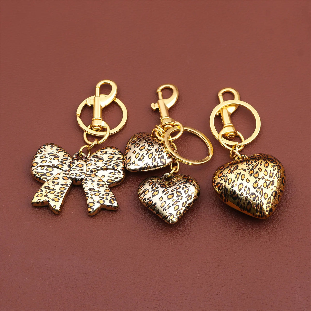 Gold-toned leopard print bow and heart bag charm keychain