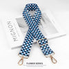Blue and white checkered nylon bag strap with gold hardware shown on a white background.