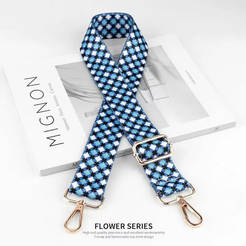 Blue and white checkered nylon bag strap with gold hardware shown on a white background.