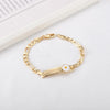 A gold-colored chain bracelet with a white daisy charm, displayed on a white background.