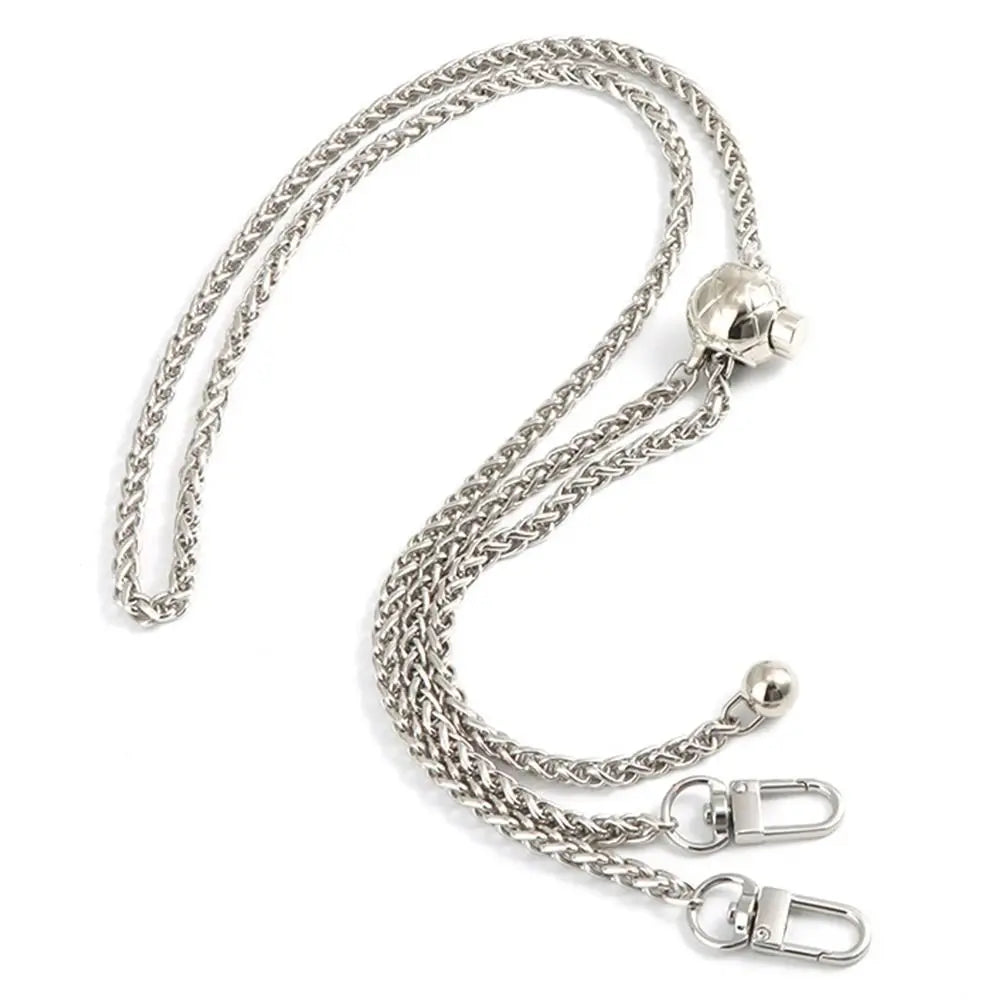 Cartera de metal plateada con cadena ajustable y dije esférico