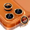 A close-up of a copper-colored camera lens protector with a metal frame and glitter diamond surface for an iPhone.