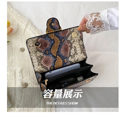 A close-up of an elegant retro crossbody bag with a patterned leather exterior and gold hardware, shown next to a hand.