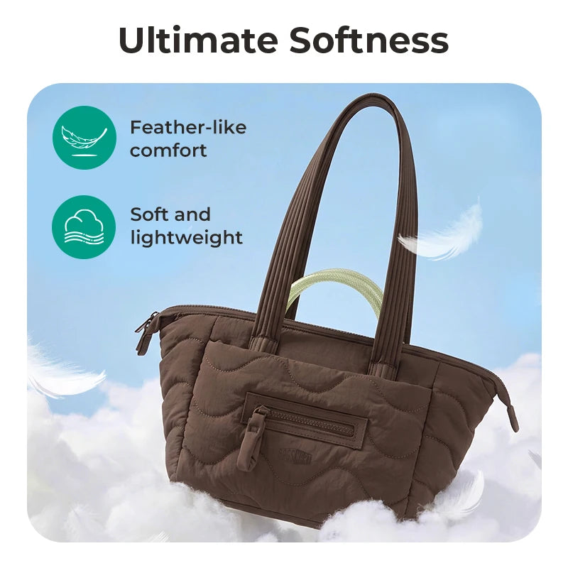 A brown quilted tote bag with a detachable strap is shown against a backdrop of fluffy white clouds.