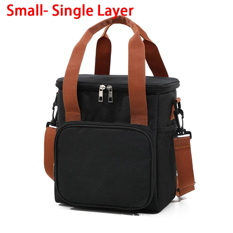 A black insulated lunch bag with brown straps and a zippered pocket.