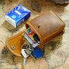 A brown leather multi-functional waist bag with a flap, featuring a small blue box and various keys.