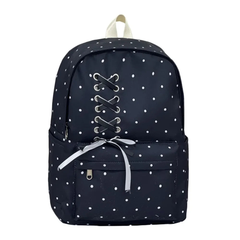 Navy blue corduroy backpack with white polka dots and a light beige strap