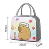 A gray insulated lunch bag featuring a cartoon capybara design with pink and yellow accents.
