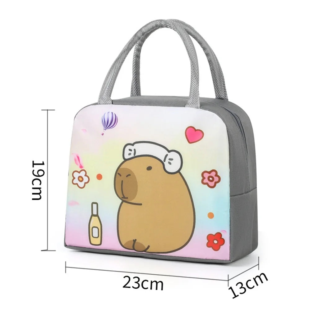 A gray insulated lunch bag featuring a cartoon capybara design with pink and yellow accents.