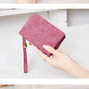 Una mano sostiene una cartera de cuero PU retro plegable morado en varios ángulos.