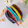 A stack of lightweight travel makeup bags in various dopamine colors including yellow, cyan, pink, and blue.