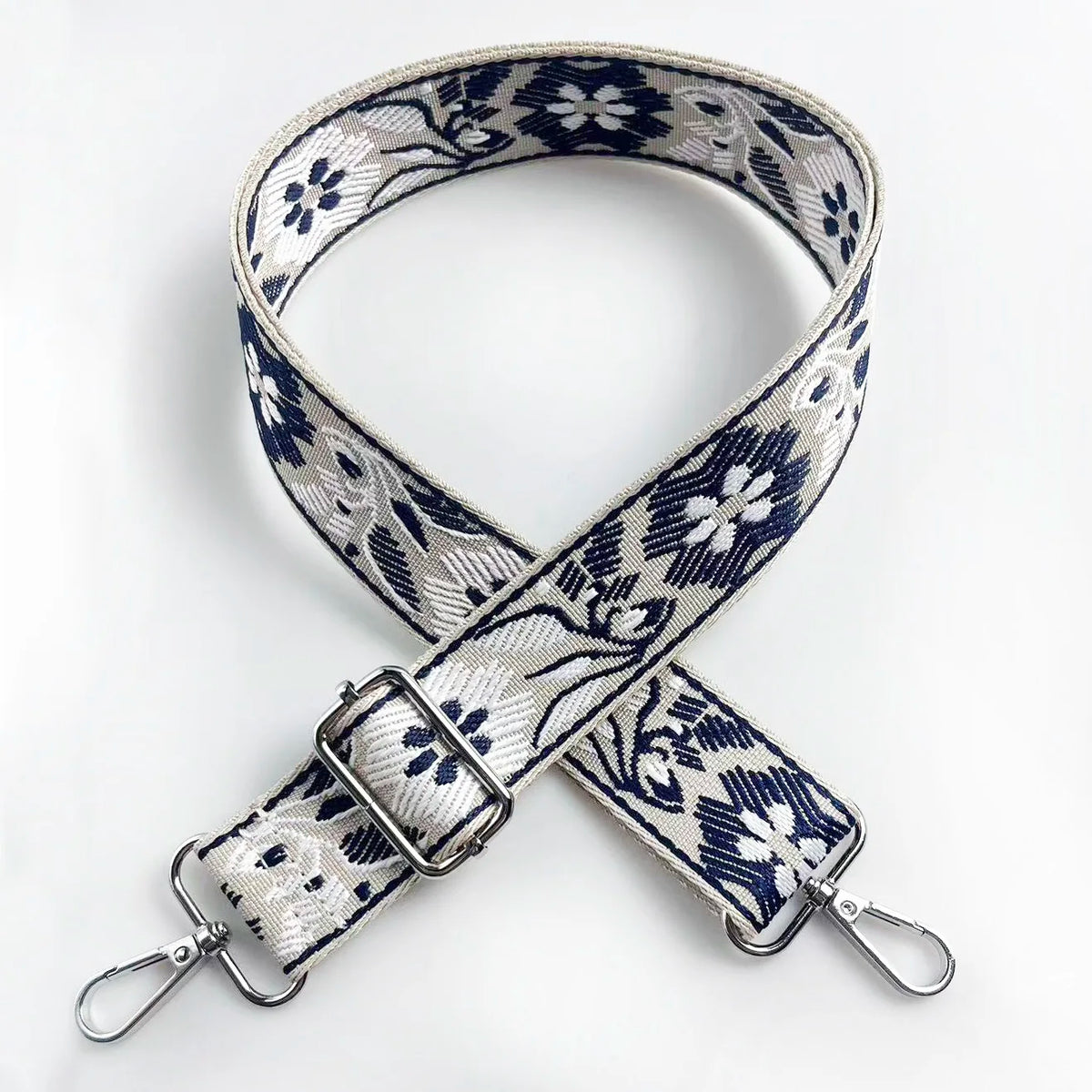 A close-up of a patterned fabric strap featuring blue and white floral designs for an adjustable crossbody bag.
