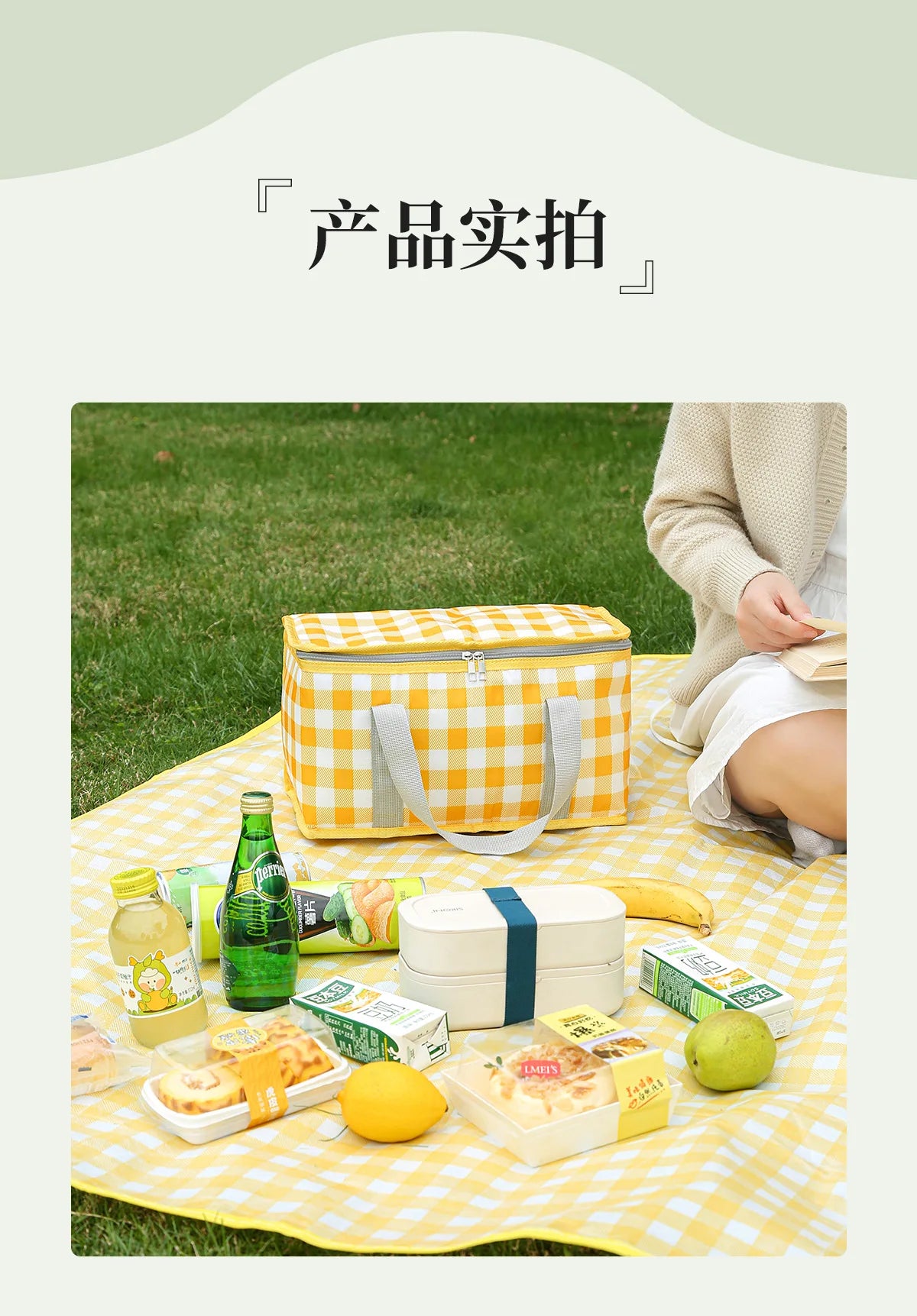 A yellow and orange insulated picnic tote is shown on a checkered cloth with various food items like bread, fruit, and drinks
