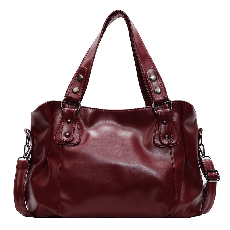 A deep burgundy leather tote bag with a crossbody strap shown from the front.