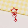 A red metal keychain clasp set featuring a star shape and a loop.