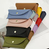 A stack of various colored PU leather hard shell sunglasses cases in shades of blue, pink, yellow, green, and black.