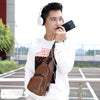 A young man wearing a white sweatshirt and carrying a brown chest bag with a headphone port, looking to the side.
