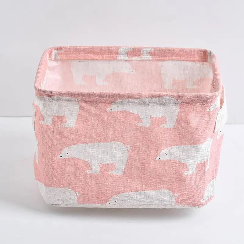 A pink storage basket with a white pattern of bears on a white background.