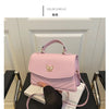 A pink women's solid texture shoulder messenger bag displayed on a black surface.