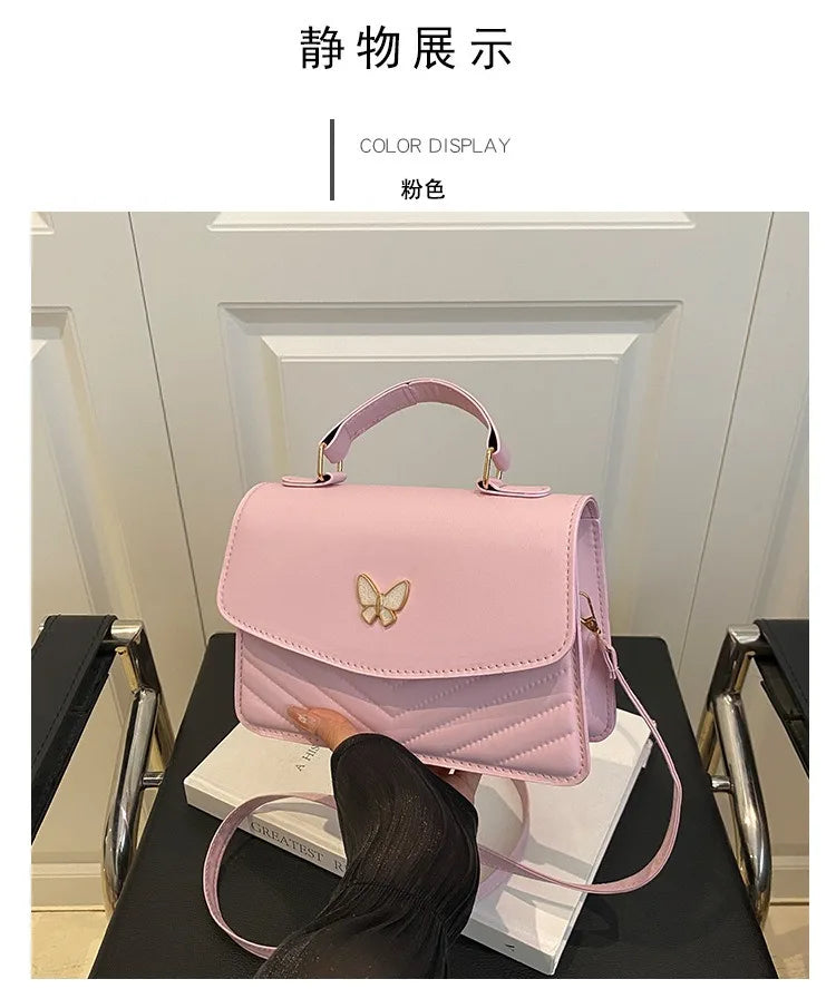 A pink women's solid texture shoulder messenger bag displayed on a black surface.