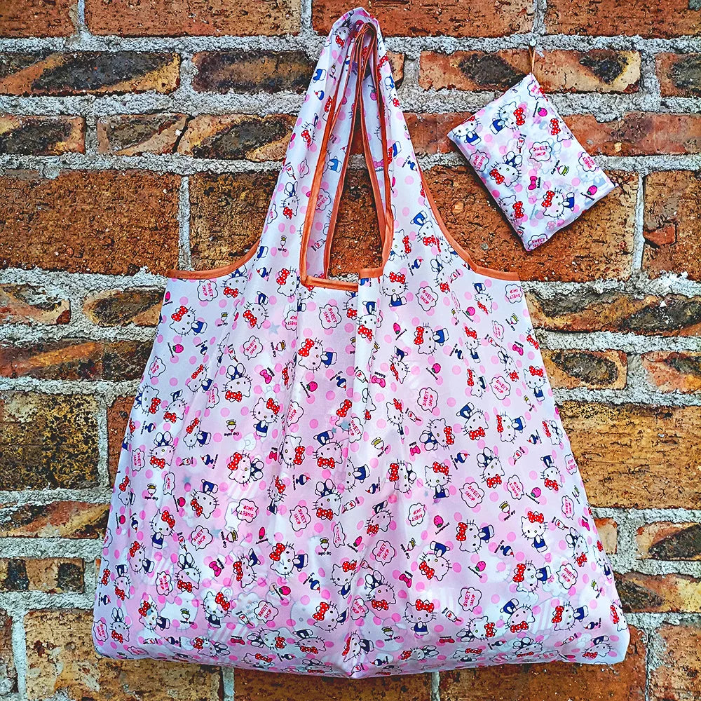 A pink and white patterned foldable reusable shopping bag hanging against a brick wall.
