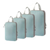 A set of four light blue travel compression packing cubes with fabric handles.