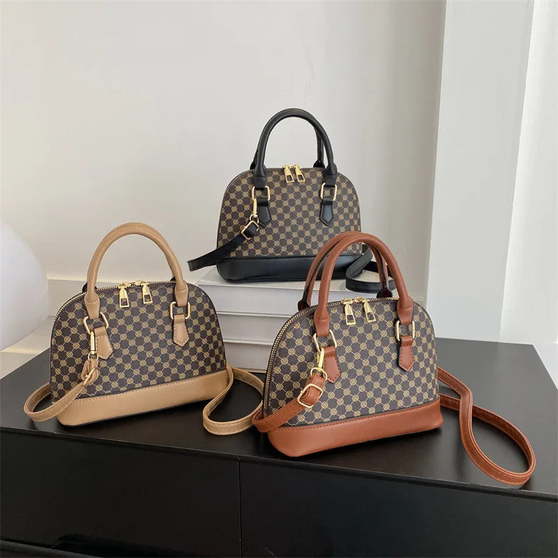 A tan patterned fashion shell shoulder crossbody bag displayed on a dark surface.