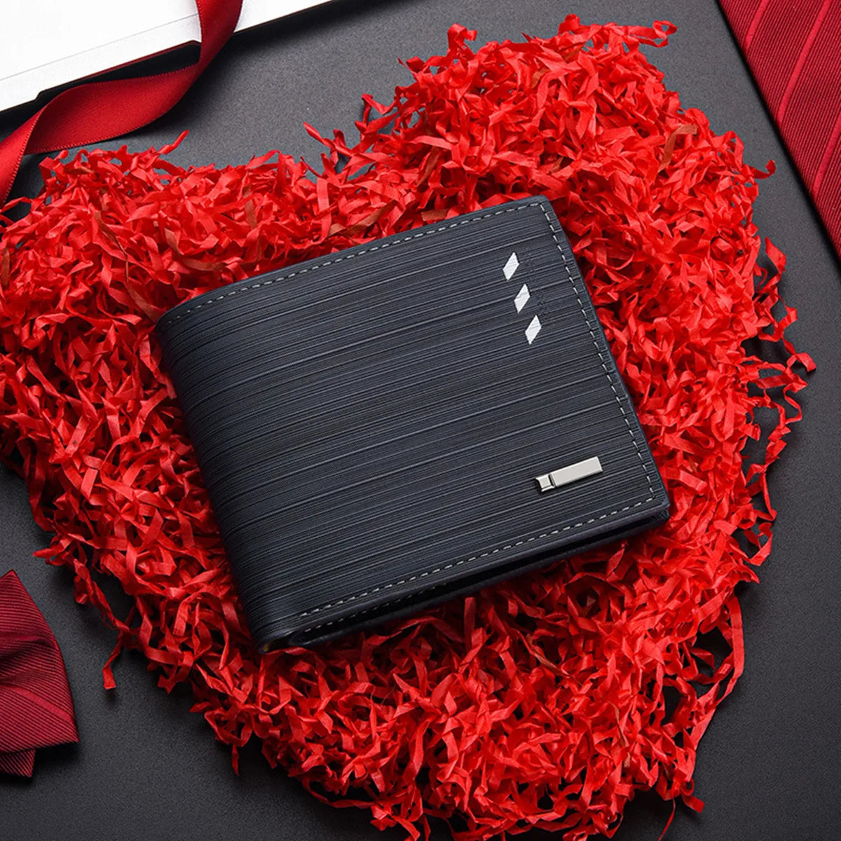 Cartera negra para hombre de PU con múltiples compartimentos sobre un fondo rojo y rasgado.